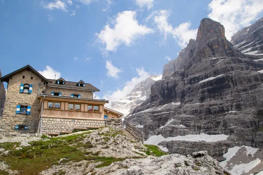 Large, stone building on top of a hill, with a large, snow-capped mountain to the right