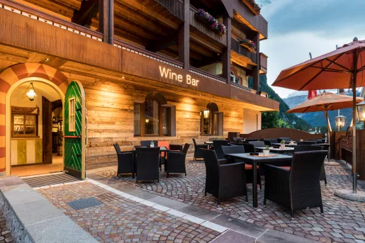 Exterior view of a large wooden hotel building with an illuminated "Wine Bar" sign