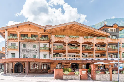 Exterior view of multi-story hotel building with mountains in the distance