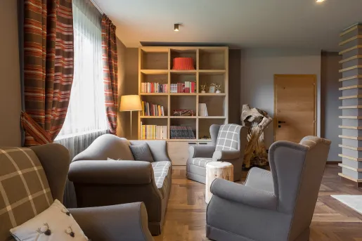 Library room with cushioned gray sofas and books in a bookshelf