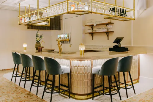 Bar with marble countertops and cushioned gray stools