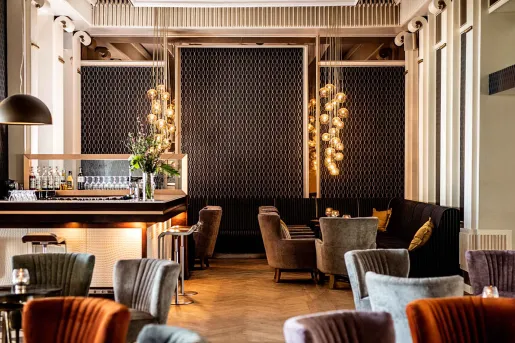 Indoor bar and lounge with cushioned seats and a bar counter to the left