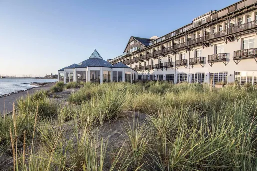 Long hotel building with outdoor balconies and the ocean to the left