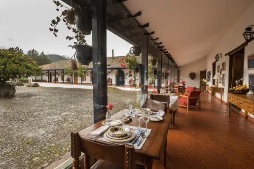 Outdoor courtyard with dining tables to the right by a building