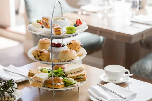 Three-tier plate full of pastries and sandwiches