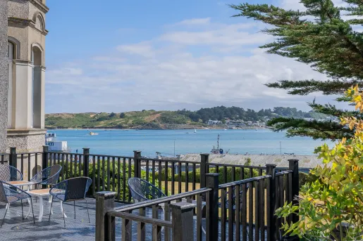 Outdoor patio with chairs and tables, looking out towards a large lake