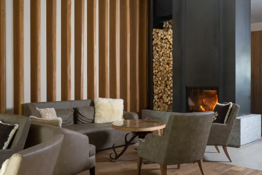 Lounge area with gray, leather couches with a fireplace to the right