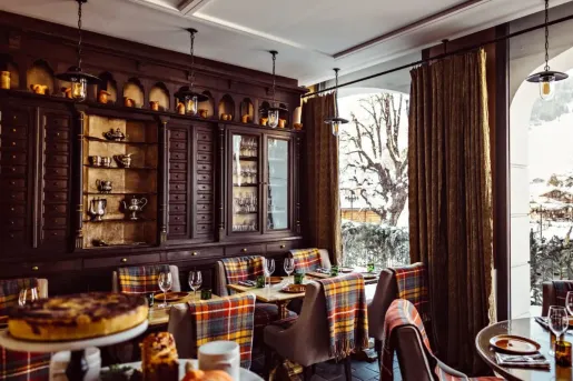 Rustic dining room with wooden furniture and plaid blankets on each chair