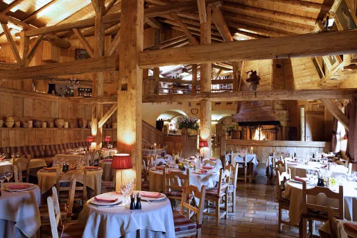 Indoor dining hall of a wooden lodge with giant wooden pillars