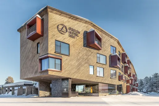 Exterior view of large, elevated hotel building with snow surrounding the building