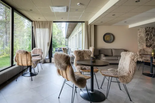 Lobby and seating area with woven chairs covered with fur cushions