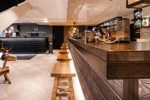 Bar counter with wooden stools, and a black counter in the background