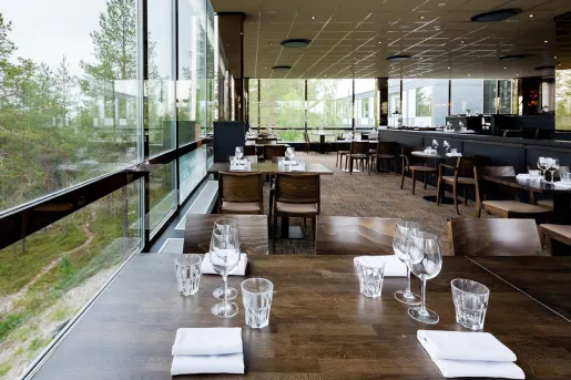 Dining area with wine glasses and handkerchiefs on each table