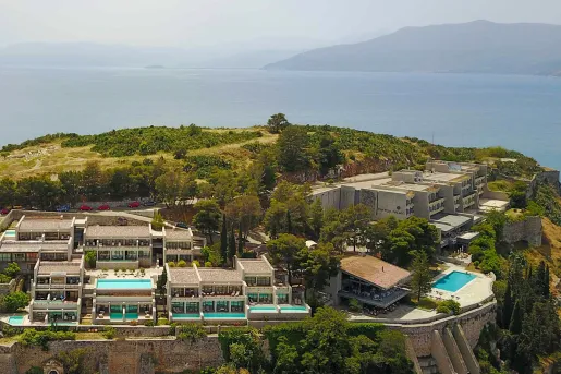 Exterior, sky view of a large hotel complex on top of a hill, with mini outdoor pools