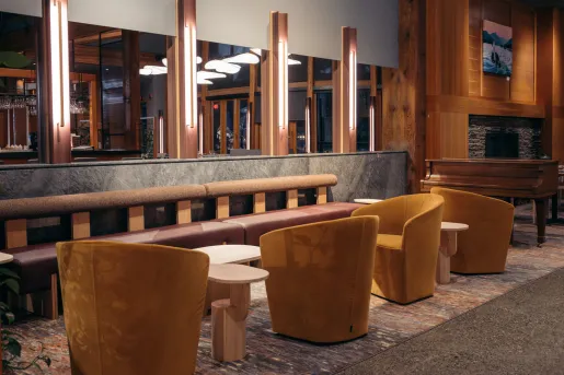 Hotel lobby seating area with cushioned chairs and illuminated, wooden pillars