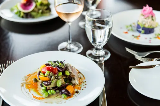 Plates full of salad and wine glasses to the right