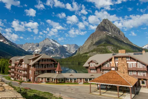 Exterior view of wooden cabin buildings in front of large lakes and mountains