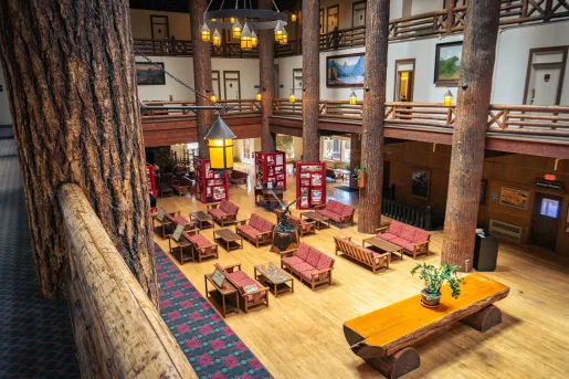 Hotel lodge lobby with cushioned seats and large, wooden pillars