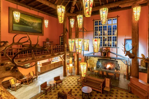 Lodge-style hotel lobby with large light fixtures and a fireplace on the ground floor