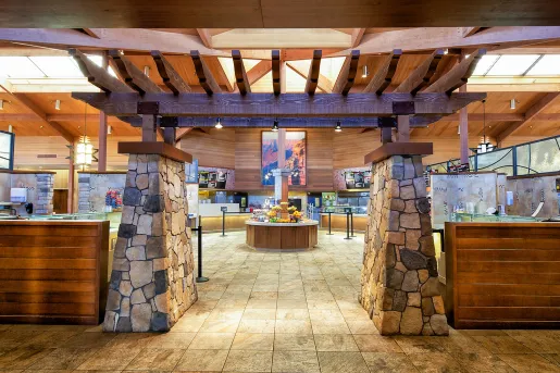 Indoor dining hall with food counters and a large stone archway