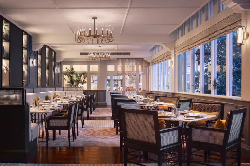 Restaurant dining hall with long wooden tables with wooden chairs