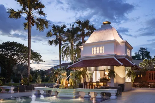 Exterior view of illuminated building with a fountain in front