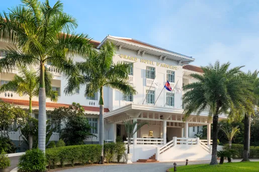Exterior view of white hotel building with flags waving in front