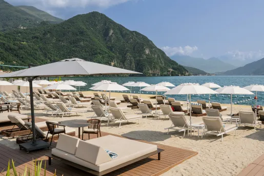 Reclining chairs lined up by the beach, with grassy gills in the distance