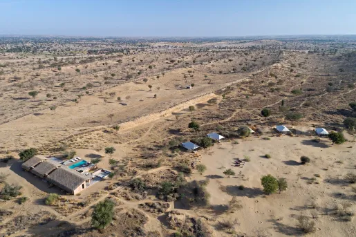 Sky view of a large desert valley with a house to the left