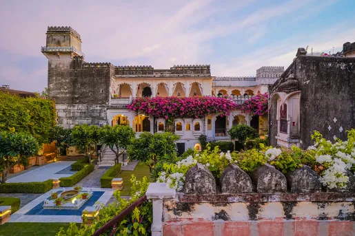 Exterior view of hotel building with flowers and an outdoor garden