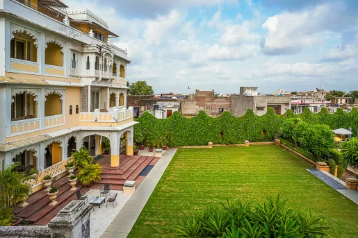 Outdoor grass area with a building with balconies on the left