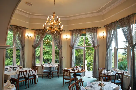 Circular room with circular dining tables and wooden chairs