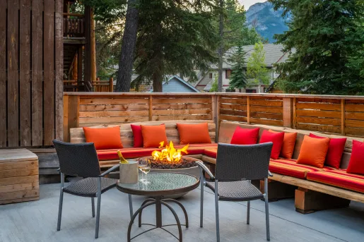 Outdoor patio with red cushioned chairs and a firepit
