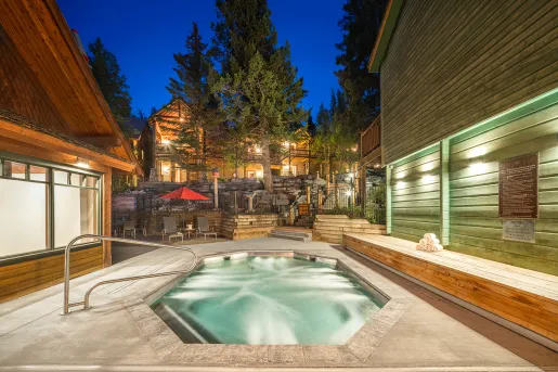 Outdoor hot tub, surrounded by large wooden cabins