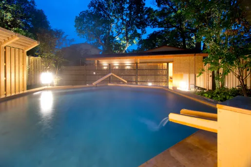 Outdoor sauna and open bath, surrounded by tall trees