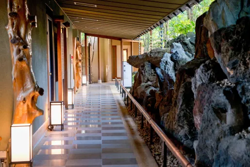 Outdoor walkway surrounded by sculpted wooden statues and large boulders
