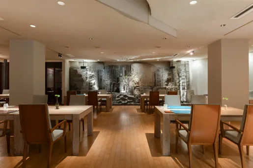 Lounge and seating area with large, wooden tables and cushioned chairs