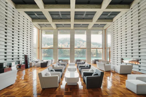 Large lounge with white and gray cushioned chairs surrounding white tables