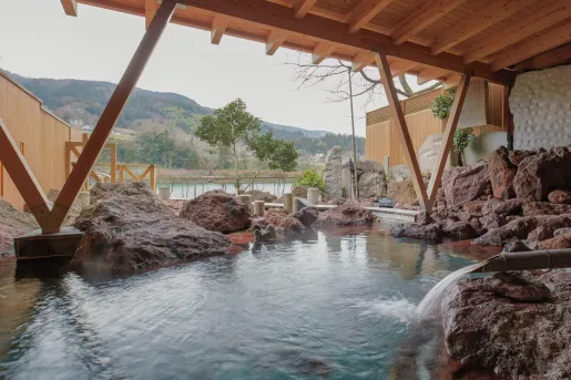 Outdoor sauna with large rocks and steaming water