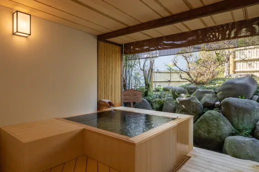 Outdoor hot tub with large boulders in front