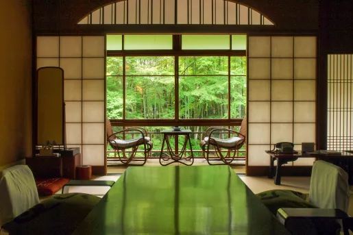 Japanese-style room with a garden outside and two chairs on a patio
