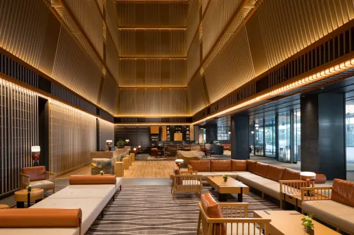 Hotel lobby interior with wooden tables and beige couches