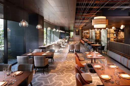 Indoor, hotel dining area with beige chairs and long wooden tables