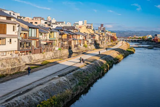 Road along a large river with houses to the left