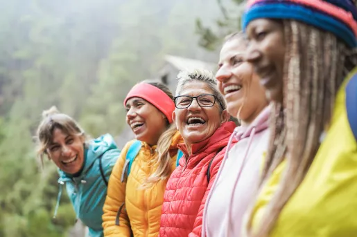 Group of women wearing jackets, smiling and looking at each other