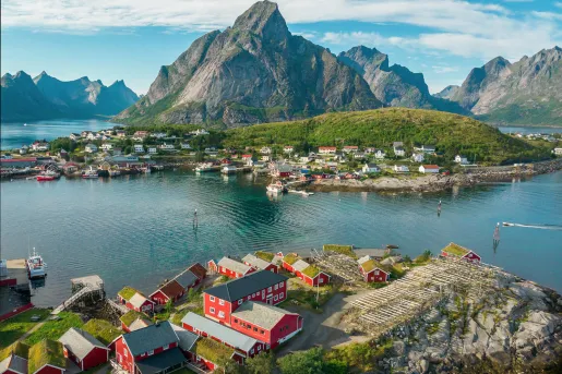 Houses along a river, with mountains in the background