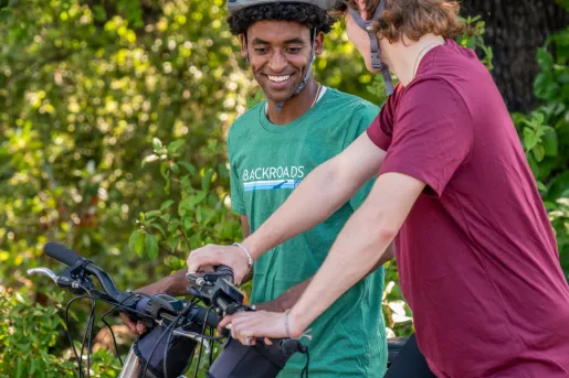 Two teenagers riding bikes while smiling