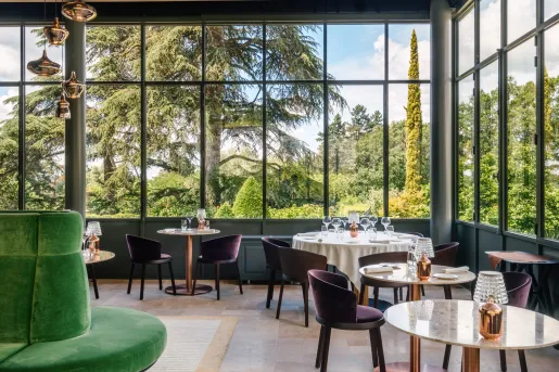 Dining area with multiple, circular tables and large windows