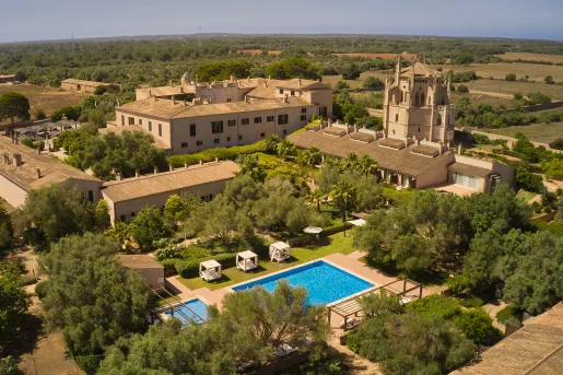 Sky view of brown, hotel buildings with an outdoor pool in the center
