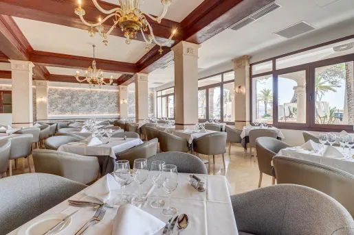 Indoor dining hall area with gray chairs and white tables